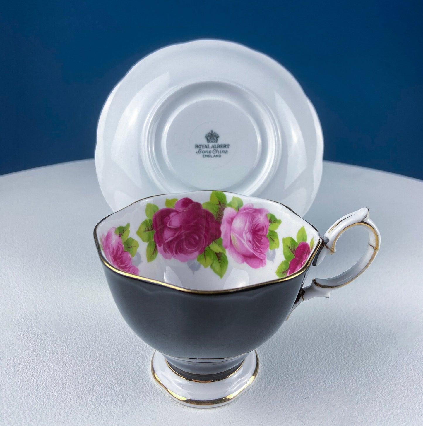 Black Cup and Saucer with Roses on White Background Inside the Cup. Royal Albert Old Country Rose Tea Set. Hand Painted Pink & Red Roses.